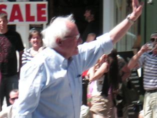 Sen Bernie Sanders waves to constituents during the Strolling of the Heifers parade 6 Jun 09